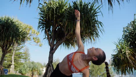 Yogi-On-Mat-Practicing-Side-Plank-On-The-Knee-And-Extending-Arm-Above---Pandanus-Trees-At-Burleigh-Hill-Near-The-Beach---Gold-Coast,-QLD,-Australia