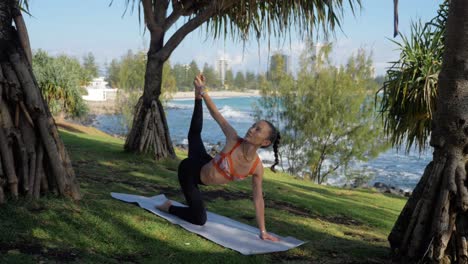 Mujer-Delgada-Haciendo-Pose-De-Tigre-En-Una-Alfombra---Yoga-En-La-Playa---Playa-De-Burleigh-Heads-En-Queensland,-Australia