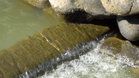 Ein-Kleiner-Wasserfall,-Der-In-Ein-Kleines-Vir-Fließt,-Viele-Schöne-Wasserspritzer