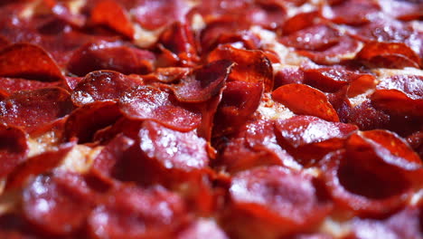 Pizza-covered-in-mouth-watering-pepperoni-and-fresh-from-the-oven---slow-push-forward-close-up