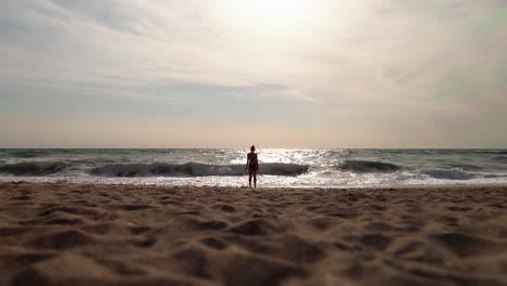 Woman-alone-looking-to-the-waves-at-the-beach