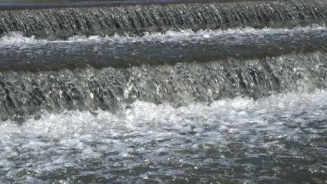 El-Agua-Salpicada-Fluye-Sobre-Una-Pequeña-Cascada-Artificial