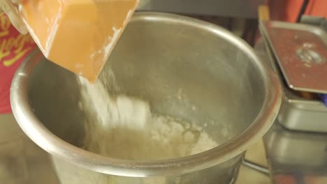Flour-Being-Poured-into-Large-Mixing-Bowl