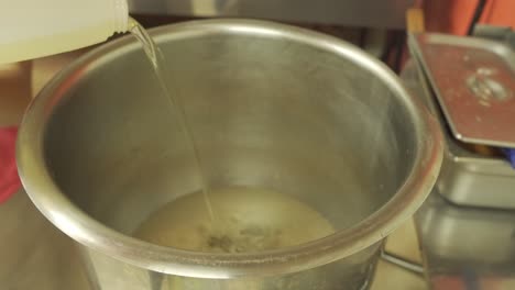 Oil-Being-Poured-into-Large-Mixing-Bowl
