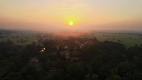 AERIAL:-a-drone-flying-backward-above-an-ancient-temple-hidden-in-a-forest-at-dawn