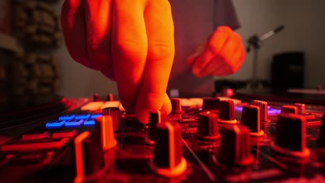 DJ-Mixing-Music-On-Turn-Table-Close-Up-On-Fingers-Turning-Knobs-With-Colored-Lights-Flashing-Ultra-Wide-Lens