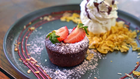 chocolate-cake-lava-with-strawberry-and-vanilla-ice-cream-on-black-plate