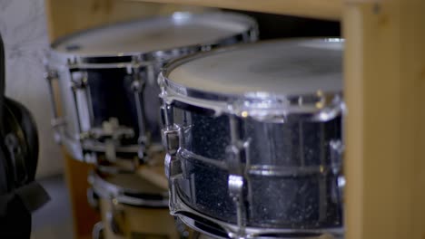 Two-snare-drums-laying-in-a-wooden-shelf-in-a-recording-studio
