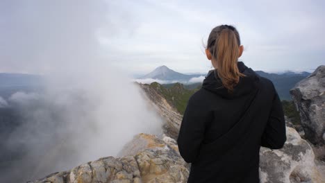 Slow-motion-shot-of-young-female-hiker-enjoying-the-view-from-Mount-Sibayak-volcano-in-North-Sumatra,-Indonesia