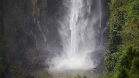 Slow-motion-shot-of-water-from-Sipiso-Piso-Waterfall-in-North-Sumatra,-Indonesia-hitting-lake-at-the-bottom