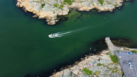 Speedboat-Swiftly-Sailing-On-The-Turquoise-Blue-Sea-In-Saltholmen-Peninsula,-Sweden---Classic-Bathing-Spot-In-Gothenburg---aerial-drone,-slow-motion