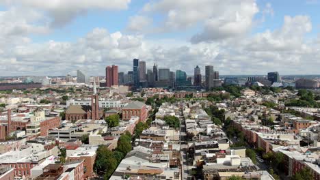 Aerial-truck-shot,-Baltimore-Maryland-USA-skyline,-cityscape-on-summer-day,-downtown-financial-business-district,-neighborhood-homes-and-community-housing-in-foreground