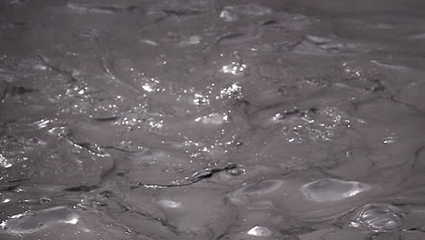Turbulent-mud-glistens-in-sunlight-in-slow-motion