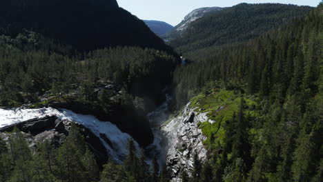 Aerial-view-towards-the-RjukanFossen-waterfall,-sunny,-summer-day,-in-Tinn,-Agder,-South-Norway---tilt-down,-drone-shot