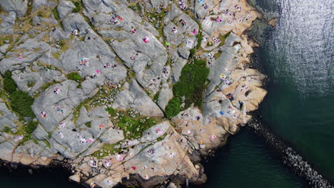 Tourists-Picnicking-On-The-Rocky-Coast-In-Saltholmen-Peninsula,-Gothenburg,-Sweden---aerial-drone