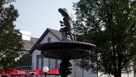 Seitenansicht-Einer-Jungen-Statue-Oben-Auf-Einem-Brunnen-Mit-Niedrigem-Winkel-An-Einem-Sonnigen-Tag