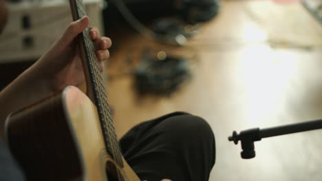 Close-up-of-a-professional-guitarist-playing-a-solo-on-a-western-acoustic-guitar-during-a-recording-session