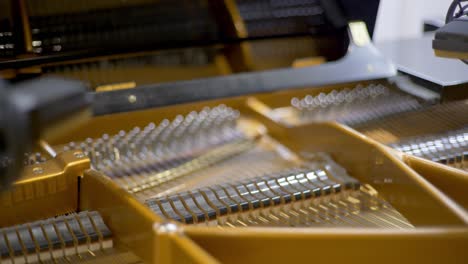 Hammers-of-an-open-concert-grand-piano-moving-during-a-recording-session-in-a-studio-with-condenser-microphones-at-the-corner-of-the-frame