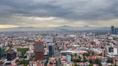 Dramatic-hyperlapse-of-an-overcast-mexico-city-with-cloud-movement-and-2-volcanoes-as-foreground,-one-of-which-has-snow