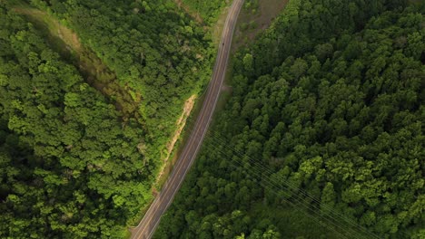 Birds-Eye-Aerial-View,-American-Freeway-in-Green-Forest-Landscape-on-Summer-Day