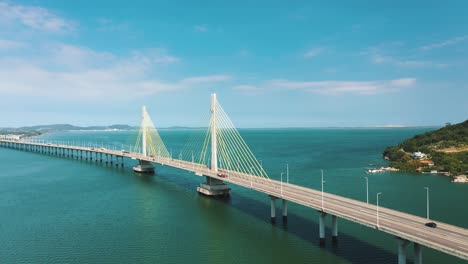 Cinematic-aerial-shot-ofAnita-Garibaldi-bridge-above-the-turquoise-color-brazilian-ocean,-located-in-Laguna,-Santa-Catarina,-Brazil