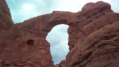 Panning-shot-across-a-sandstone-arch-formation-in-Arches-National-Park,-Utah