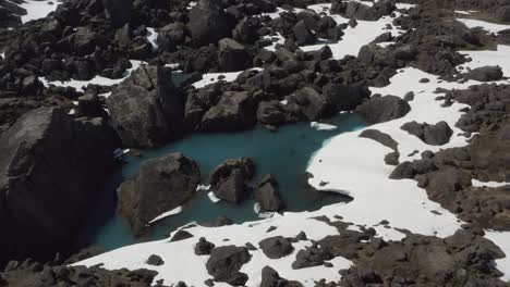 Flying-over-Turquoise-Glacial-Pools-surrounded-by-Incredible-Snow-covered-Grey-Rocks,-Nature-Drone-Aerial-Iceland