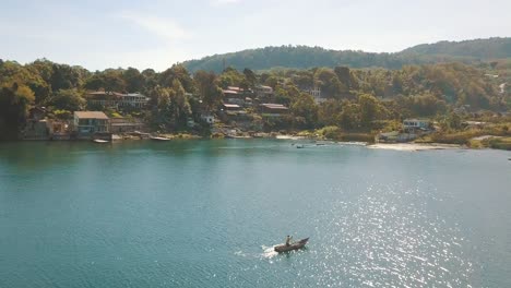 Antena-De-Drones-Volando-Sobre-Un-Pescador-Remando-En-Un-Bote-En-El-Lago-De-Atitlán,-Guatemala