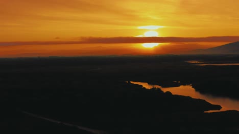 Luftaufnahmen-Von-Drohnen-Des-Sonnenaufgangs-über-Dem-Pinienwald-Im-Berühmten-Naturpark-Maremma-In-Der-Toskana,-Italien,-Mit-Einem-Dramatischen-Wolkenhimmel-über-Der-Savannenlagune