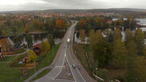 Cars-and-trucks-driving-through-a-roundabout-and-over-a-bridge-on-a-cloudy-autumn-day