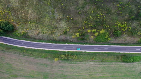Flying-over-a-winding-road-in-the-forest-with-trees-on-both-sides-in-spring