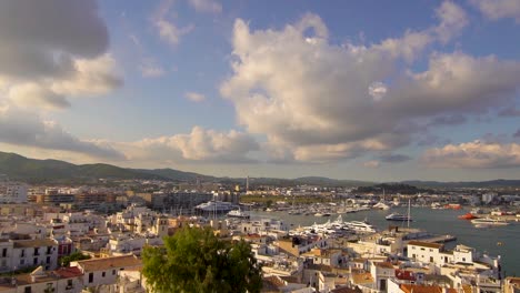 View-of-Ibiza-harbor-from-the-top-of-Dalt-Vila,-boats,-cruises,-and-the-old-town,-during-a-beautiful-sunny-summer-afternoon