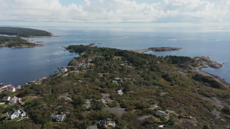 Aerial-Flyover,-Forested-Merdo-Island-in-Norway-surrounded-by-calm-sea
