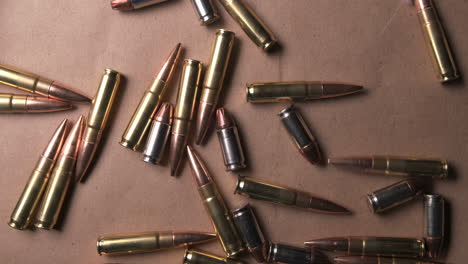 Slow-motion-footage-of-rifle-shells-and-pistol-bullets-falling-onto-table