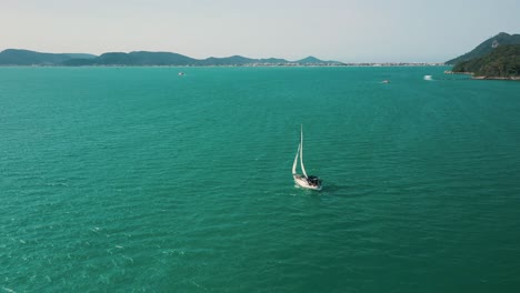 Aerial-view-of-a-sailboat-on-the-beautiful-brazilian-ocean,-Santa-Catarina,-Brazil