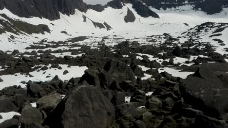 Maravillosas-Rocas-Grises-Sobresalen-Del-Suelo-Cubierto-De-Nieve-Mientras-Un-Dron-Sobrevuela,-Aéreo,-Islandia