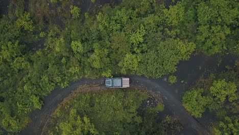 Drone-aerial-bird's-eye-view,-4x4-car-driving-off-road-over-black-sand-in-forest-during-a-camping-trip-to-Pacaya-Volcano,-Guatemala