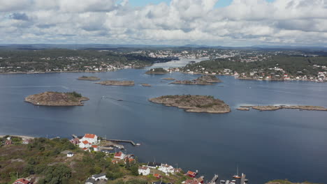 Small-islands-by-seaside-town-of-Arendal,-Norway,-Aerial-Pull-Back