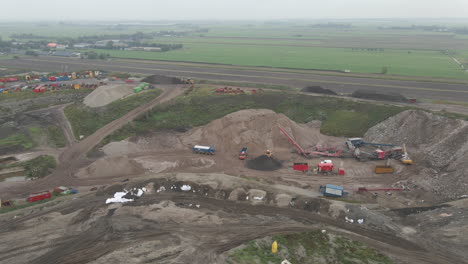 Aerial-of-busy-landfill-site-with-trucks-and-excavator