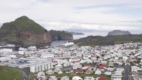 Descending-aerial-over-small-town-of-Heimaey-with-traditional-white-buildings