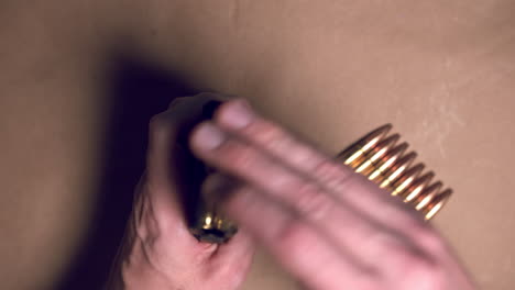 Close-Up-shot-of-hands-loading-ar-15-magazine-with-bullets