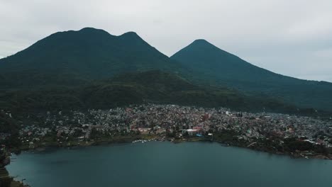 Drone-aerial-view-of-the-town-and-volcano-in-Lake-atitlan,-Guatemala