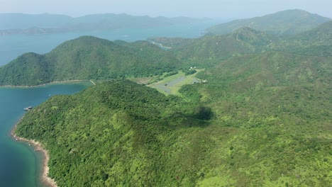 Aerial-view-of-Hong-Kong-bay-with-lush-green-mountain-terrains