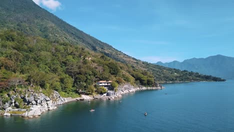 Local-Fisherman-boats-paddling-and-A-beautiful-day-in-Lake-Atitlan,-Guatemala---Drone-aerial-view