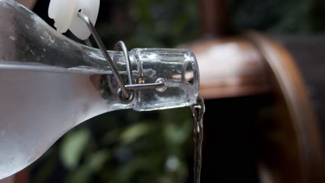 Chef-pouring-cold-water-from-a-glass-bottle