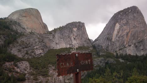Tilting-up-shot-to-reveal-hiking-trailhead-sign-with-the-backside-of-Half-Dome-in-the-background