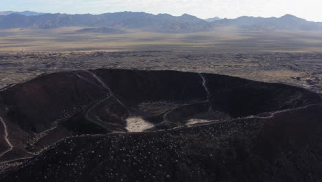 Vista-Aérea-Alejándose-Del-Cráter-Volcánico-Amboy-En-El-Desierto-De-Mojave