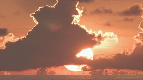 Orangefarbener-Sonnenuntergang-Mit-Wolken,-Die-Auf-Meerwasser-Aufsetzen