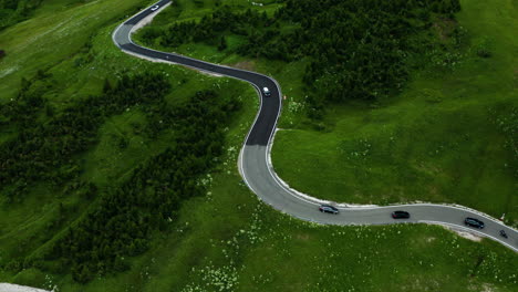 Cars-driving-down-winding-road-in-Dolomites-Gardena-mountain-pass