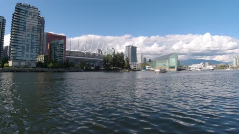 Aerial-Low-fly-by-1-foot-above-sea-level-thru-False-Creek-BC-Vancouvers-private-yacht-tour-parking-for-the-elite-few-next-to-expensive-housing-Hotel-Parq,-BC-Stadium,-Plaza-of-Nations-pier-port-dock